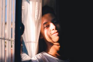 This image shows side lighting of a Photo by Raphael Brasileiro: https://www.pexels.com/photo/smiling-young-man-leaning-on-wall-6441513/